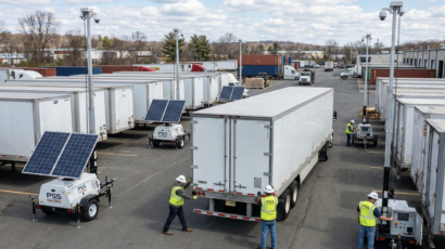 Multiple Renting portable security units are being deployed by workers in a logistics yard, highlighting their flexibility for large-scale security needs.